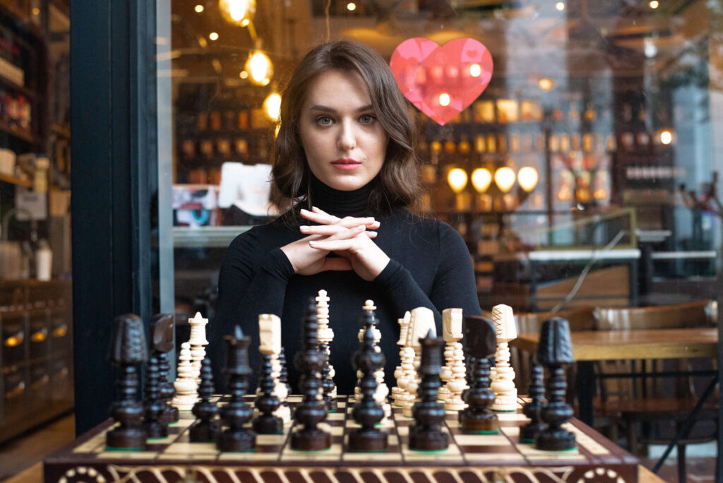 brunette woman cups hands with chess board