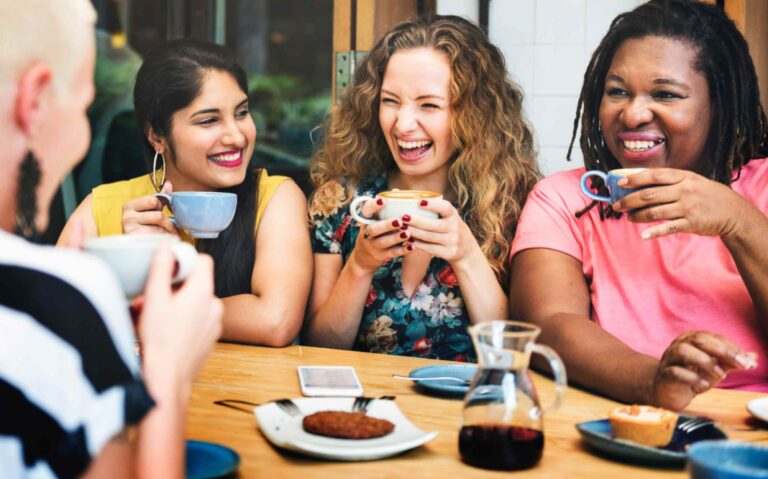 Four women networking while drinking coffee.